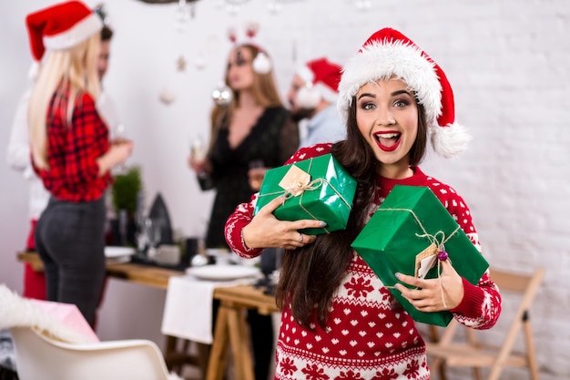 Portret van een jonge vrouw met groene geschenkdozen thuis op de voorgrond mooie brunette in een san...