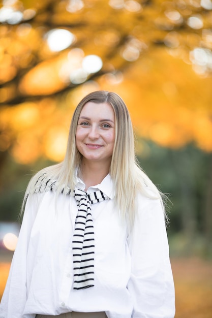 Portret van een jonge vrouw met herfst esdoorn bladeren buiten