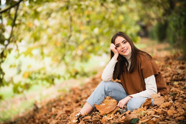 Portret van een jonge vrouw met herfstbladeren romantische meisjesdroomgreep herfstesdoornbladeren herfstseizoen