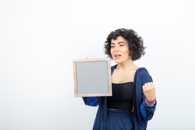 Portret van een jonge vrouw met het frame van de krullend haarholding.