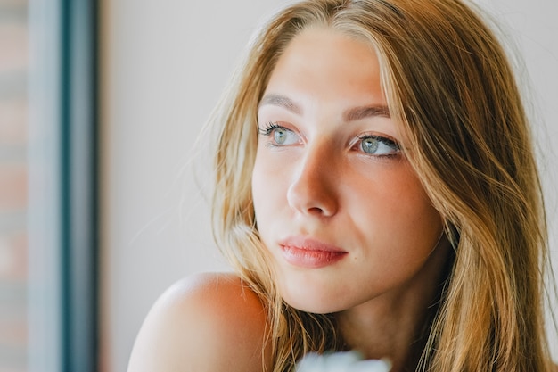 Portret van een jonge vrouw met natuurlijk haar en grijze ogen