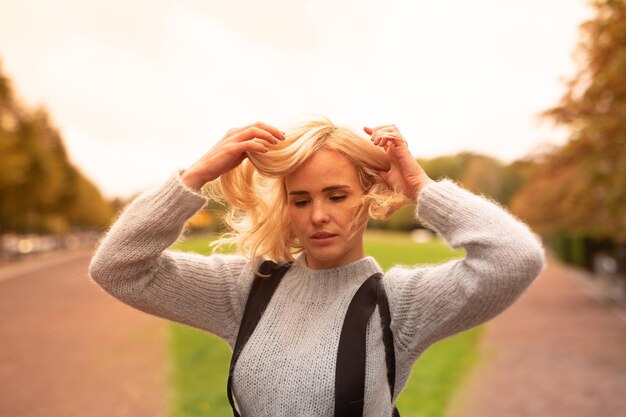 Foto portret van een jonge vrouw met opgeheven armen die tegen de lucht staat