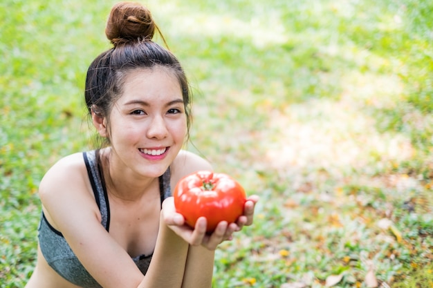 Portret van een jonge vrouw met tomaat