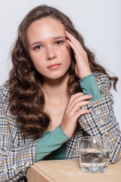 Portret van een jonge vrouw met waterglas Witte achtergrond geïsoleerd Portret van een vrouw die water drinkt Glimlachend meisje Geïsoleerd portret