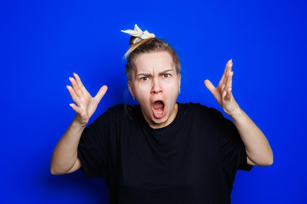 Portret van een jonge vrouw op een blauwe achtergrond die haar hoofd vasthoudt Hoofdpijn migraine bij een vrouw