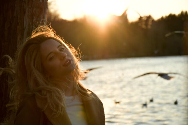 Foto portret van een jonge vrouw tegen de hemel bij zonsondergang