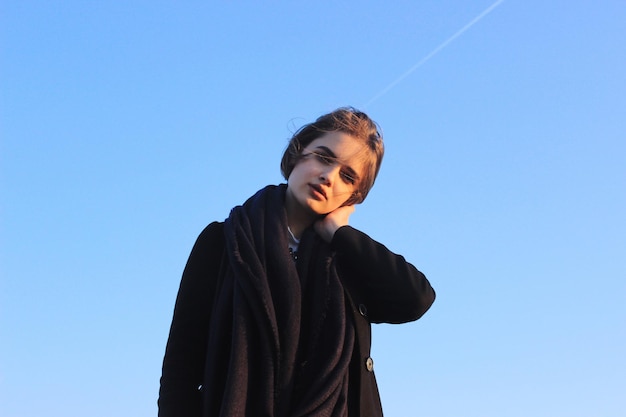 Portret van een jonge vrouw tegen een heldere lucht