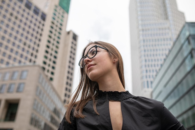 Portret van een jonge vrouw tegen gebouwen in de stad