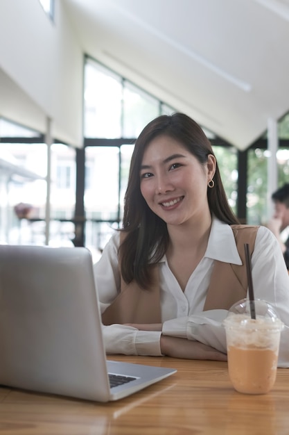 Portret van een jonge vrouwelijke freelancer werkt met laptop in moderne kantoren