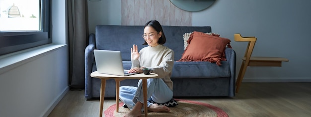 Portret van een jonge werkende vrouw Koreaans meisje dat studeert op afstand online praten met laptop videochat