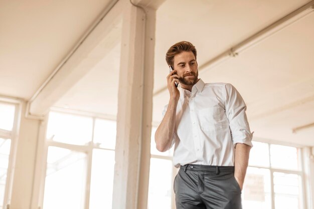 Portret van een jonge zakenman aan de telefoon in een loft