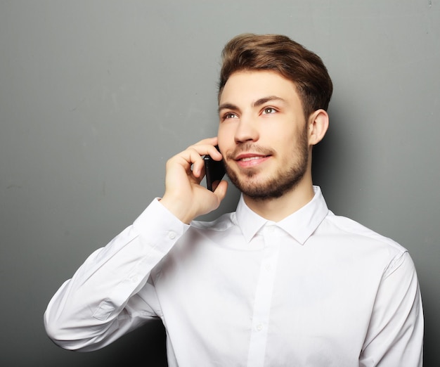 Portret van een jonge zakenman die op de telefoon spreekt