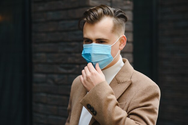 portret van een jonge zakenman in een wegwerpmasker