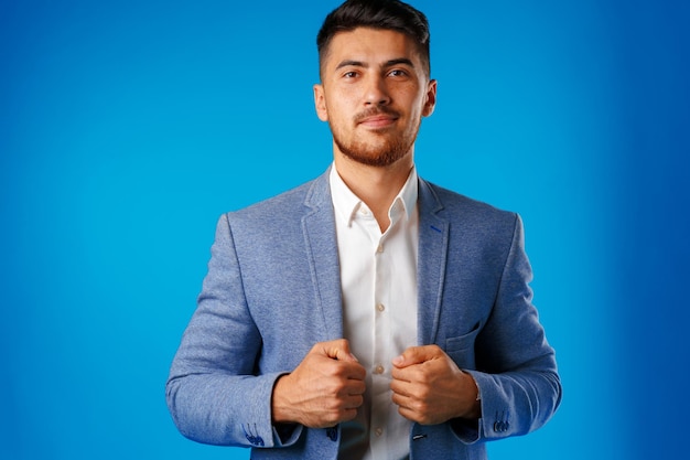Portret van een jonge zakenman van gemengd ras tegen een blauwe achtergrond