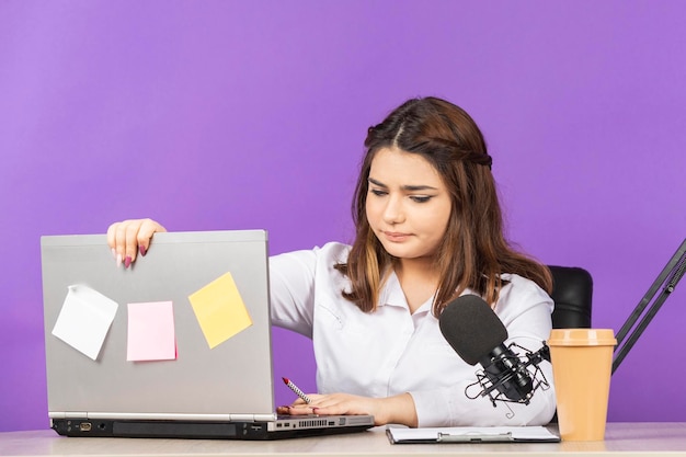 Portret van een jonge zakenvrouw die achter het bureau zit en haar dagelijkse werk doet foto van hoge kwaliteit