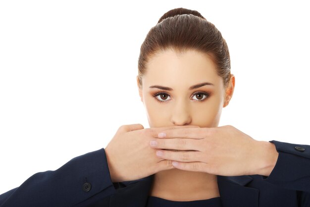 Foto portret van een jonge zakenvrouw die haar mond bedekt tegen een witte achtergrond