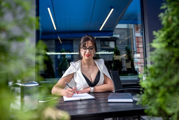 Portret van een jonge zakenvrouw die koffie drinkt terwijl ze buitenshuis aan een laptop werkt