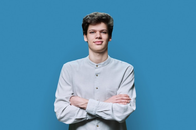 Portret van een jonge zelfverzekerde man op blauwe achtergrond