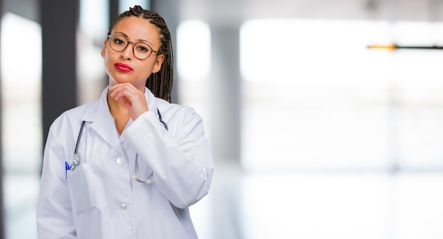 Portret van een jonge zwarte arts vrouw denken en opzoeken