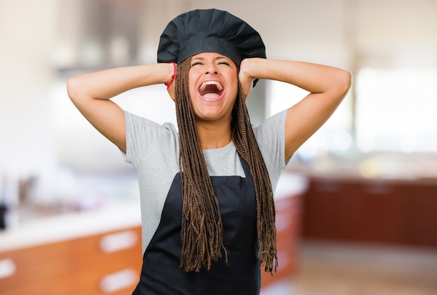 Portret van een jonge zwarte bakkersvrouw, gek en wanhopig, schreeuwend uit de hand