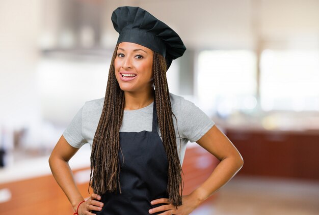 Portret van een jonge zwarte bakkersvrouw met handen op heupen