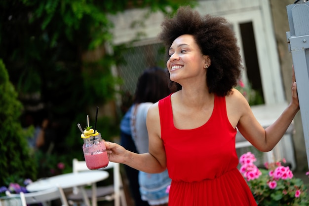 Portret van een jonge zwarte vrouw, modemodel met een jurk met afro-kapsel