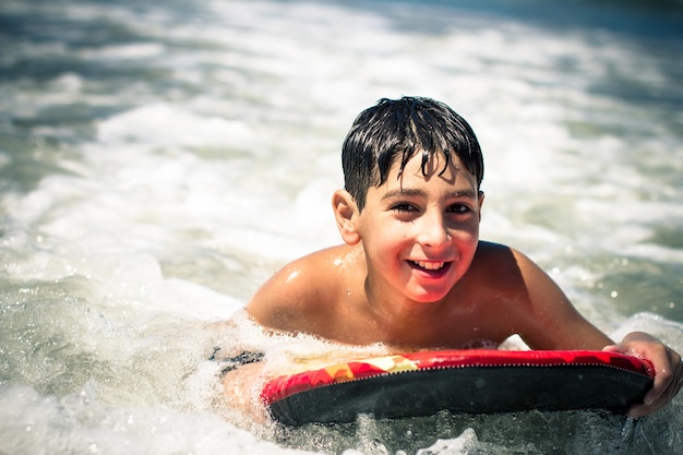 Portret van een jongen die bodysurft in de zee