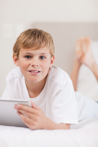 Portret van een jongen die een tabletcomputer met behulp van