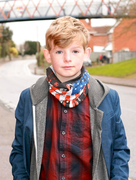 Foto portret van een jongen die op de weg staat