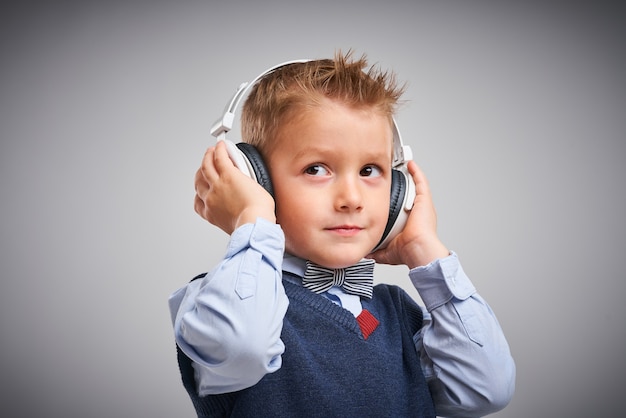 Portret van een jongen die zich voordeed over wit met een koptelefoon