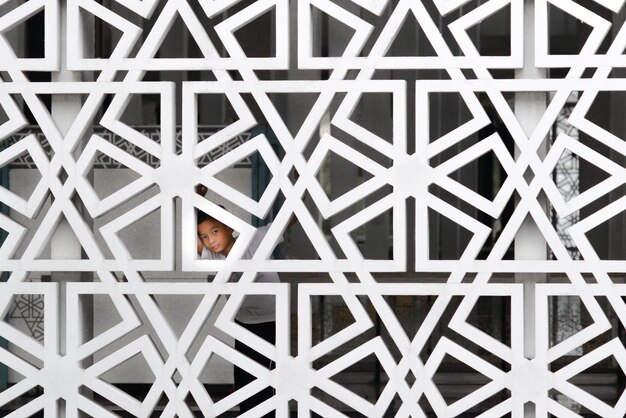 Portret van een jongen gezien door een gebouwde structuur