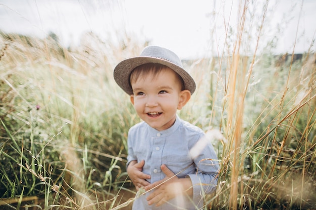 Portret van een jongen in een hoed op de weide