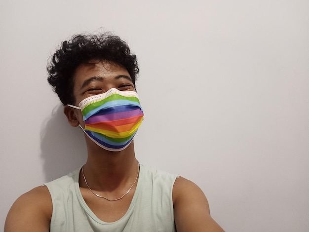 Foto portret van een jongen met regenboogmaskers op een witte achtergrond