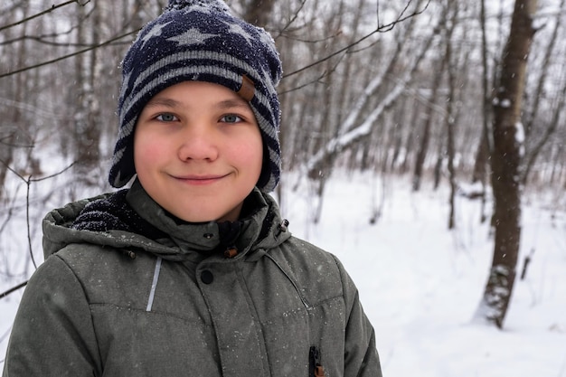 Portret van een jongen op de achtergrond van een winterbos