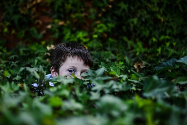 Foto portret van een jongen te midden van planten