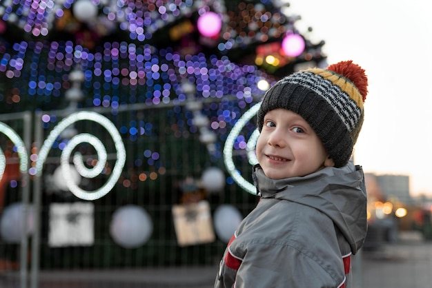 Portret van een jongen tegen de achtergrond van de kerstboom Voorbereidingen voor Kerstmis