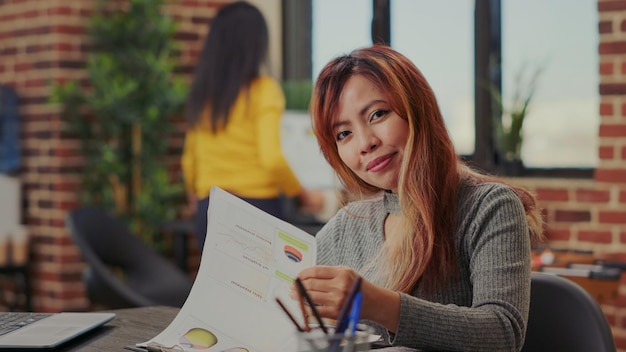 Portret van een kantoormedewerker die financiële documenten bekijkt om de marketingpresentatie voor ontwikkeling te plannen. Zakenvrouw die grafiekenanalyse gebruikt om aan succesvolle investeringen en groei te werken.