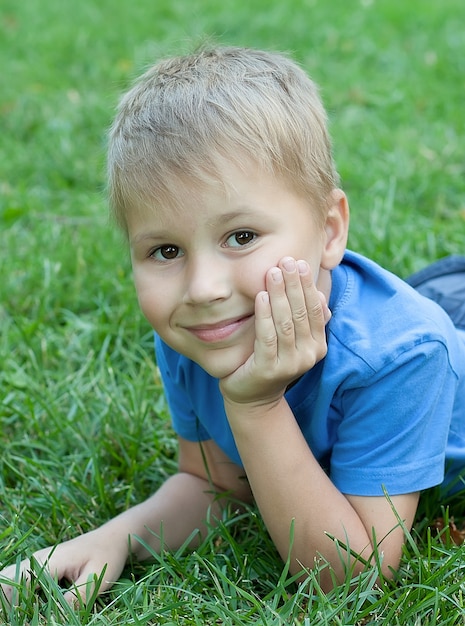 Portret van een kind dat op het gras ligt