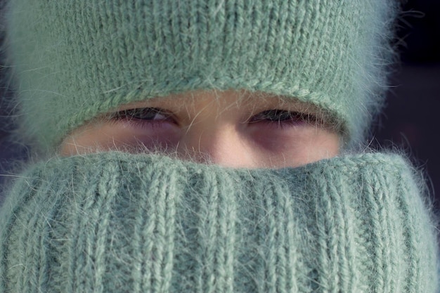 portret van een kind in gebreide warme muts en sjaal