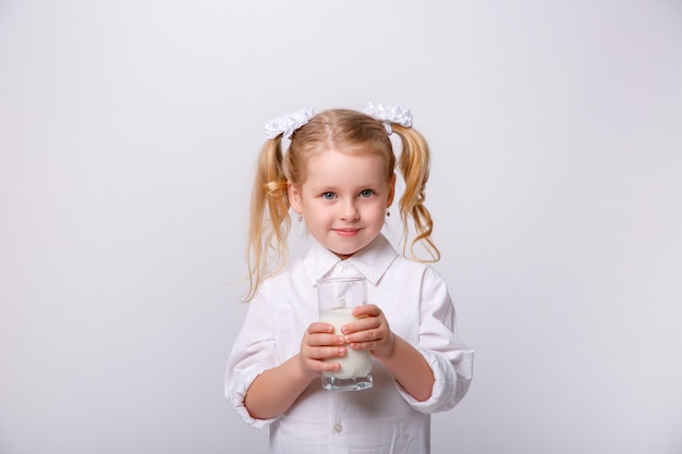 Portret van een klein gelukkig meisje met glas melk.