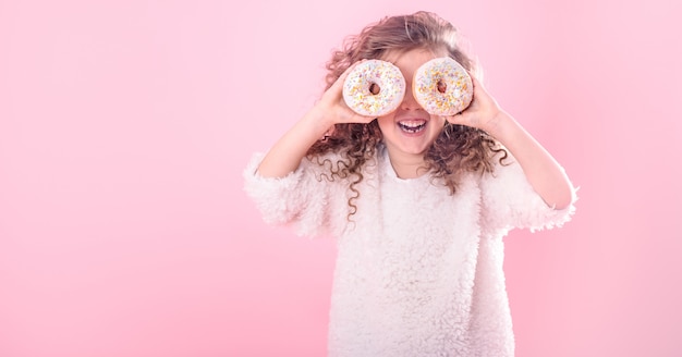 Portret van een klein glimlachend meisje met donuts