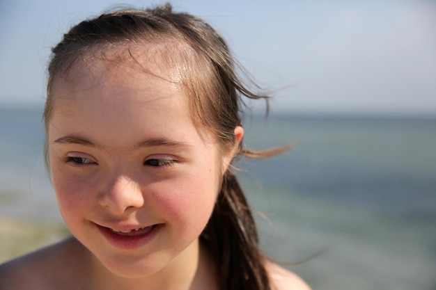 Portret van een klein meisje dat lacht op de achtergrond van de zee