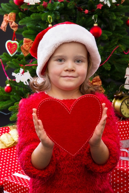 Foto portret van een klein meisje dat rood hart houdt