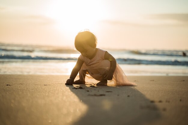 Portret van een klein meisje genieten van een vakantie op het strand spelen met zand