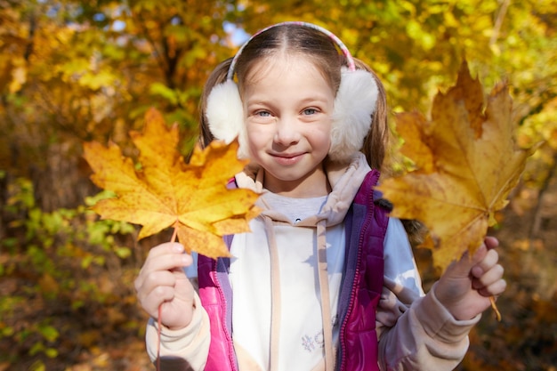 Portret van een klein meisje in een herfstpark op een zonnige dag