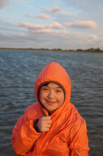 Portret van een klein meisje op de achtergrond van de lucht en het water