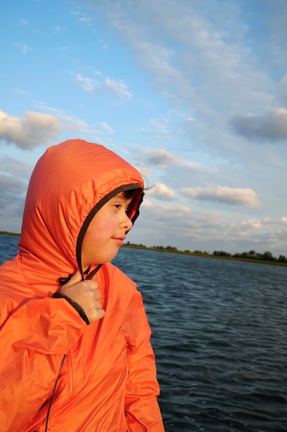 Portret van een klein meisje op de achtergrond van het water en de lucht