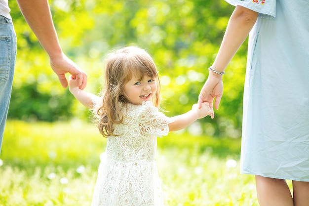 Portret van een klein mooi meisje dat hand in hand loopt met haar ouders close-up