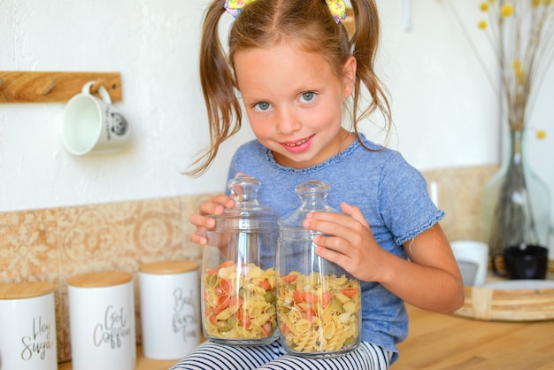 portret van een klein schattig meisje in de keuken met boodschappen en gezonde voeding
