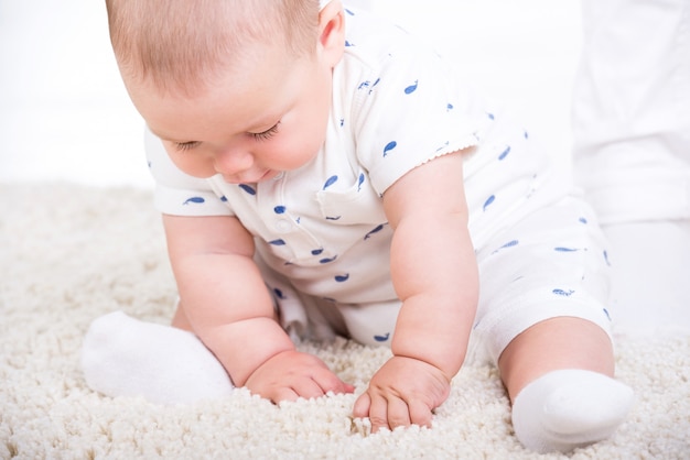 Portret van een kleine babyjongen zit op de vloer.